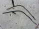 1995 Ford Bronco - Two metal tubes, likely automotive parts, are shown on a concrete surface with scattered leaves.