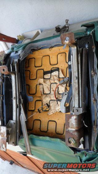 Green car seat interior with exposed springs and foam