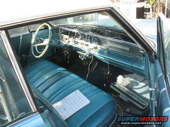 Teal interior of a classic car with a notebook on the seat