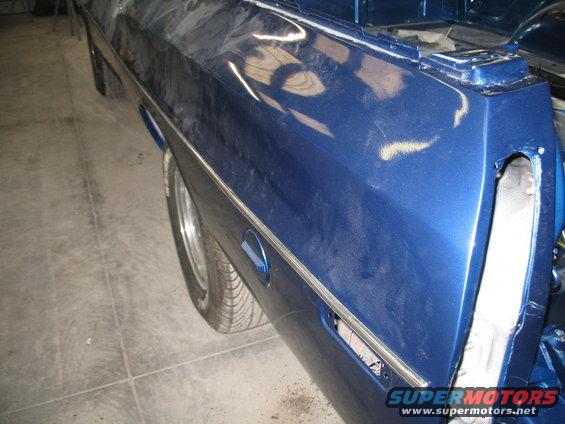 Blue pickup truck bed with chrome trim and a gas cap door. Tail light area is open