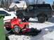 1986 Ford Bronco - A person works on a red toy truck while a lifted 1986 Ford Bronco sits nearby in a snowy setting.