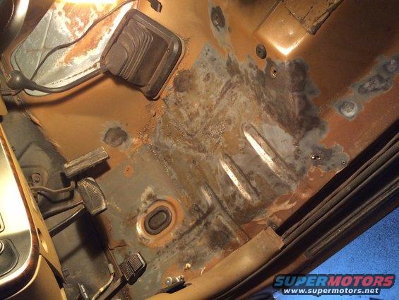 rusted floor pan and transmission tunnel with gear shifter boot