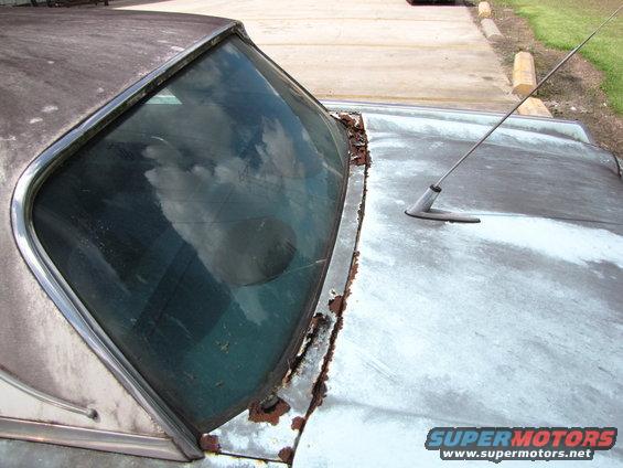 1963 Ford Thunderbird hood and windshield frame with rust and a radio antenna