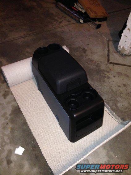 Black center console with dual cup holders and storage compartment