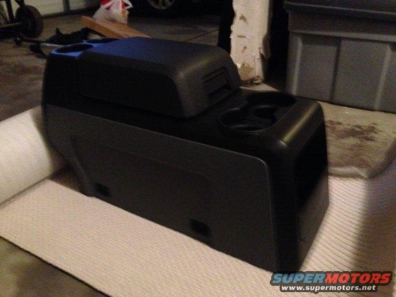 Black center console with dual cup holders and storage compartment
