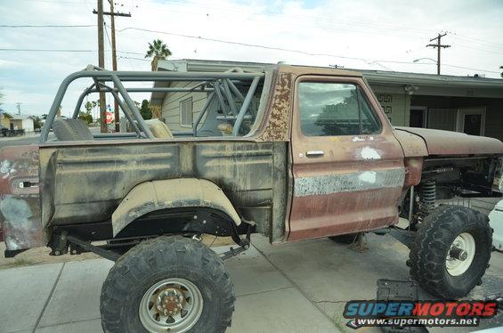 Modified Ford Bronco body with roll cage, missing front clip and fenders