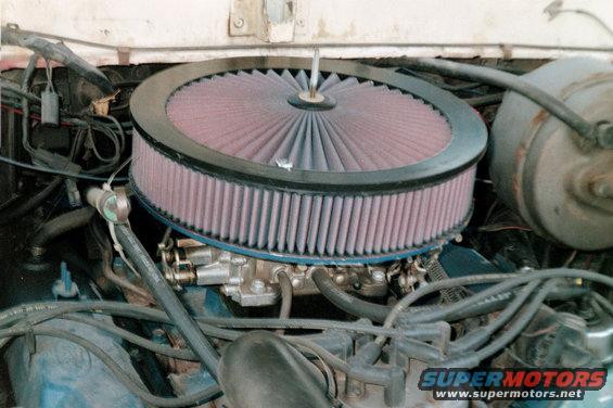 Engine bay with large round air filter over carburetor