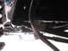 1988 Ford Bronco - A close-up view of a vehicle's undercarriage reveals various mechanical parts and tubing.