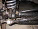 1988 Ford Bronco - This image shows the front suspension components of a vehicle, covered in dirt and mud.