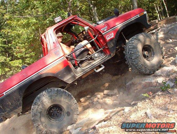 1988 Ford Bronco climbing steep rocky terrain, driver visible inside
