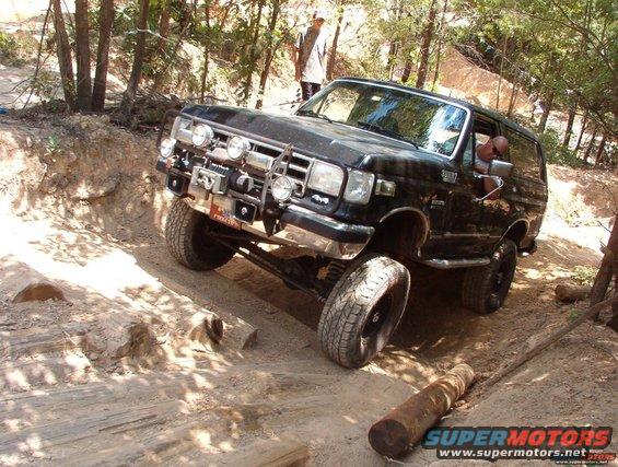 Black Ford Bronco with winch and auxiliary lights navigating an off-road trail