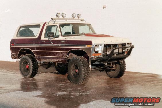 Maroon and white 1979 Ford Bronco with off-road tires and light bar