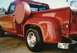 1967 Ford F-100 - A red 1967 Ford F-100 pickup truck is viewed from the rear quarter, showing its spare tire mounted externally.