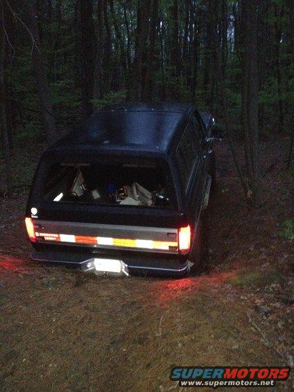 1988 Ford Bronco parked on dirt path in forest, rear view