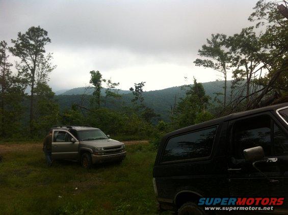 Black Ford Bronco parked on grassy terrain with a silver SUV in the background