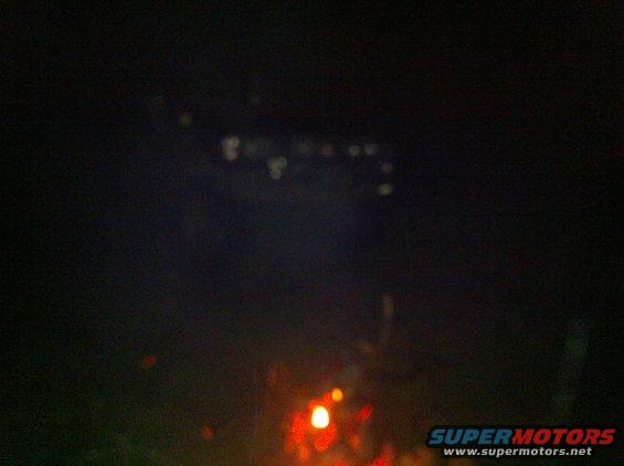 Blurry lights and reflections at night, with a watermark for Supermotors.net