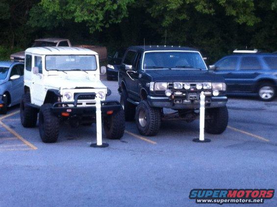 Black Ford Bronco and white Suzuki Samurai parked side-by-side