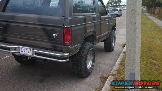 Dark brown Ford Bronco with lifted suspension and off-road tires, viewed from the rear quarter