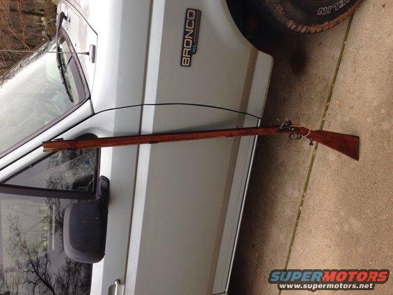 Side view of a 1996 Ford Bronco with a long rifle laid across its side