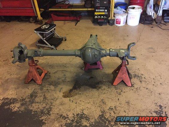 Vehicle rear axle assembly on jack stands in a garage