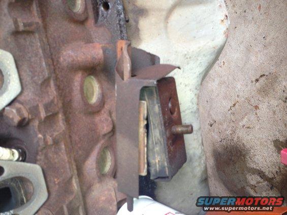 Rusty engine mount bracket attached to a cast iron block