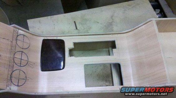 Interior dashboard console with cutouts and speaker circles, unfinished wood