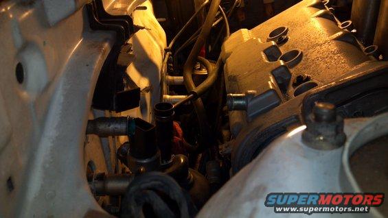Engine bay with hoses and engine block visible. A watermark reads SUPERMOTORS.NET