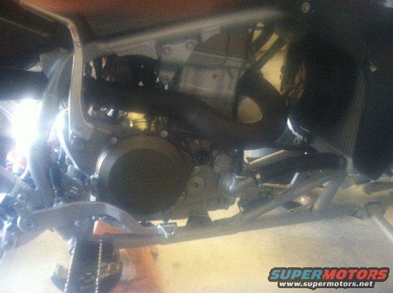 Close-up of a motorcycle's engine and frame, viewed from below