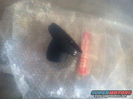 Black plastic part with red label, possibly for a vehicle