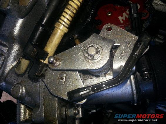 Throttle body linkage with metal arm and yellow-striped hose
