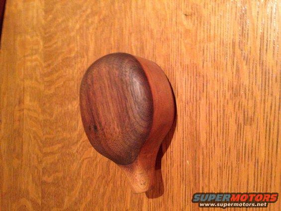 Wooden knob attached to a wood-grained surface. Supermotors.net logo in lower right