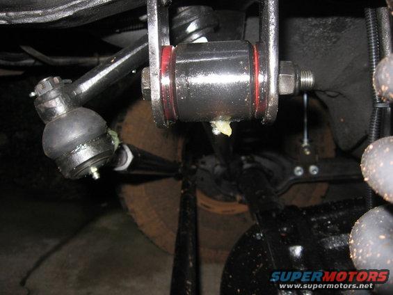 Close-up of a suspension component, possibly a tie rod end, with grease visible