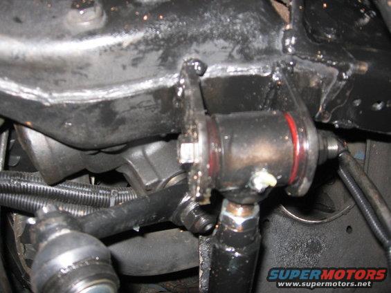 close-up of vehicle steering linkage with red and black components