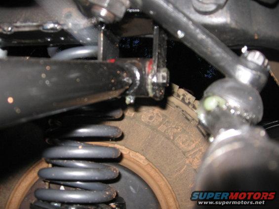 Close-up of suspension components and tire tread with visible text