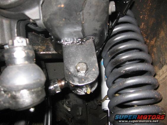 Close-up of a vehicle's suspension system, showing a coil spring and linkage