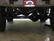 1988 Ford Bronco - Undercarriage view showing the rear axle, suspension components, and a custom license plate.