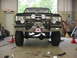 1988 Ford Bronco - Modified Ford Bronco front end with winch and auxiliary lights, lifted suspension visible.