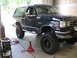 1988 Ford Bronco - A dark blue Ford Bronco is parked in a garage with welding equipment nearby.