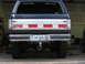 1988 Ford Bronco - The rear of a dark blue SUV is shown, a silver tailgate insert with red and white stripes and a Georgia license plate.