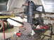 1988 Ford Bronco - Vehicle suspension components, including large coil springs and brake assembly, are visible during a repair or modification.