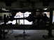 1988 Ford Bronco - The underside of a vehicle is shown being worked on, with a white truck in the background.