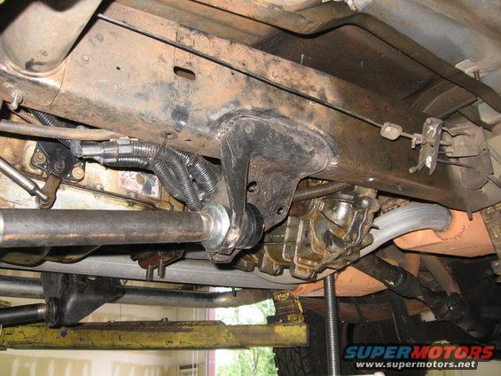 Undercarriage of a vehicle with visible suspension components, exhaust, and drivetrain parts