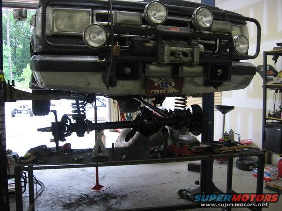 1988 Ford Bronco front end with winch and auxiliary lights, raised on a lift for service