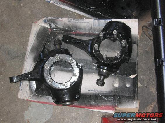 Pair of black steering knuckles on a cardboard box