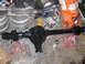 1988 Ford Bronco - A black rear axle assembly is supported by red jack stands amidst various automotive parts and supplies.
