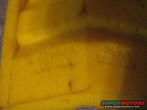Yellow plastic part with embossed text and a watermark for www.supermotors.net