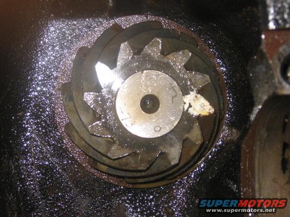 Close-up of a differential gear with metal shavings in oil