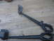 1988 Ford Bronco - Two black metal suspension components are laid out on a weathered wooden deck.