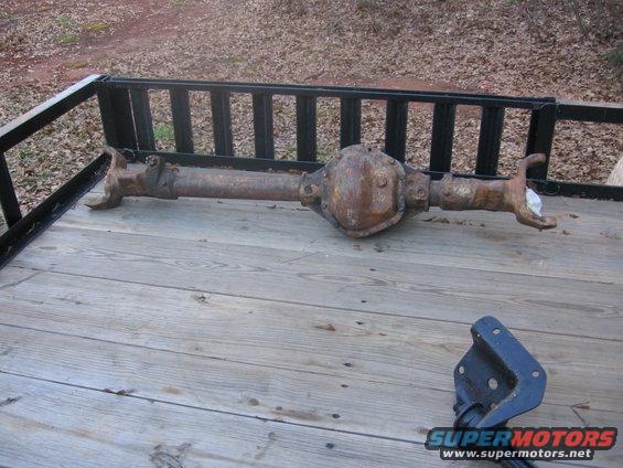 Rusted rear axle assembly on a wooden trailer bed