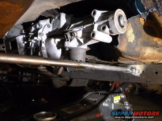 Transmission assembly and rusted frame under a vehicle, supported by a floor jack